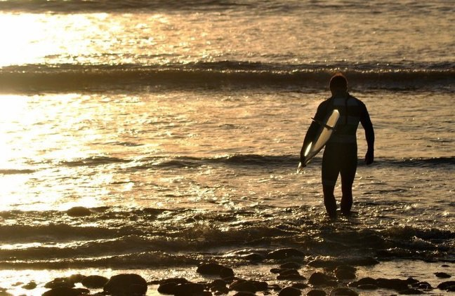 Silhouette of surfer at sunset